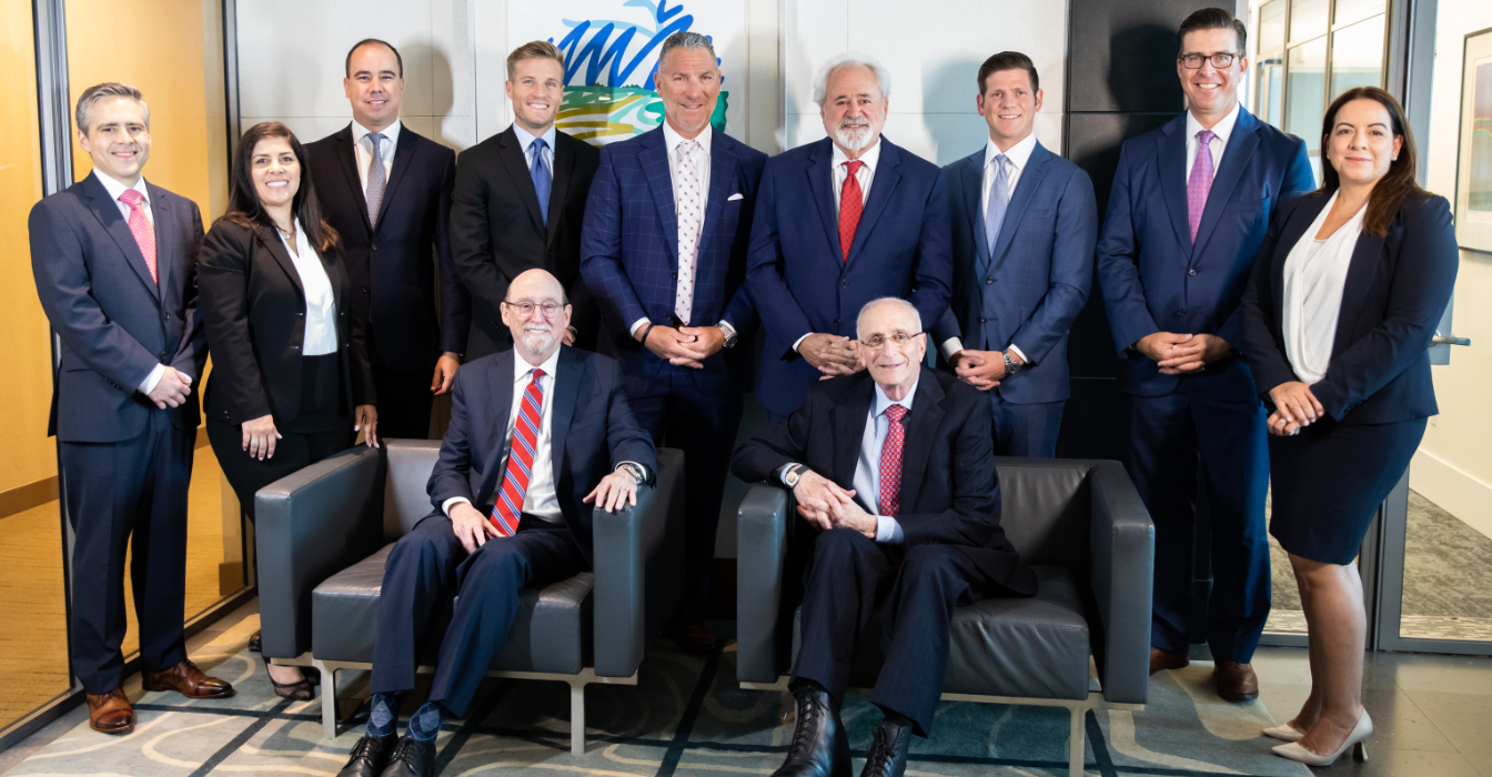 The attorneys of Grossman Roth Yaffa Cohen (standing, L to R): Alex Arteaga-Gomez, Natasha Cortes, Julian Catala, William Mulligan, Andrew Yaffa, Stuart Grossman, Ryan Yaffa, Eric Halsey and Aimee Ferrer. Sitting (L to R): Gary Cohen and Neal Roth.